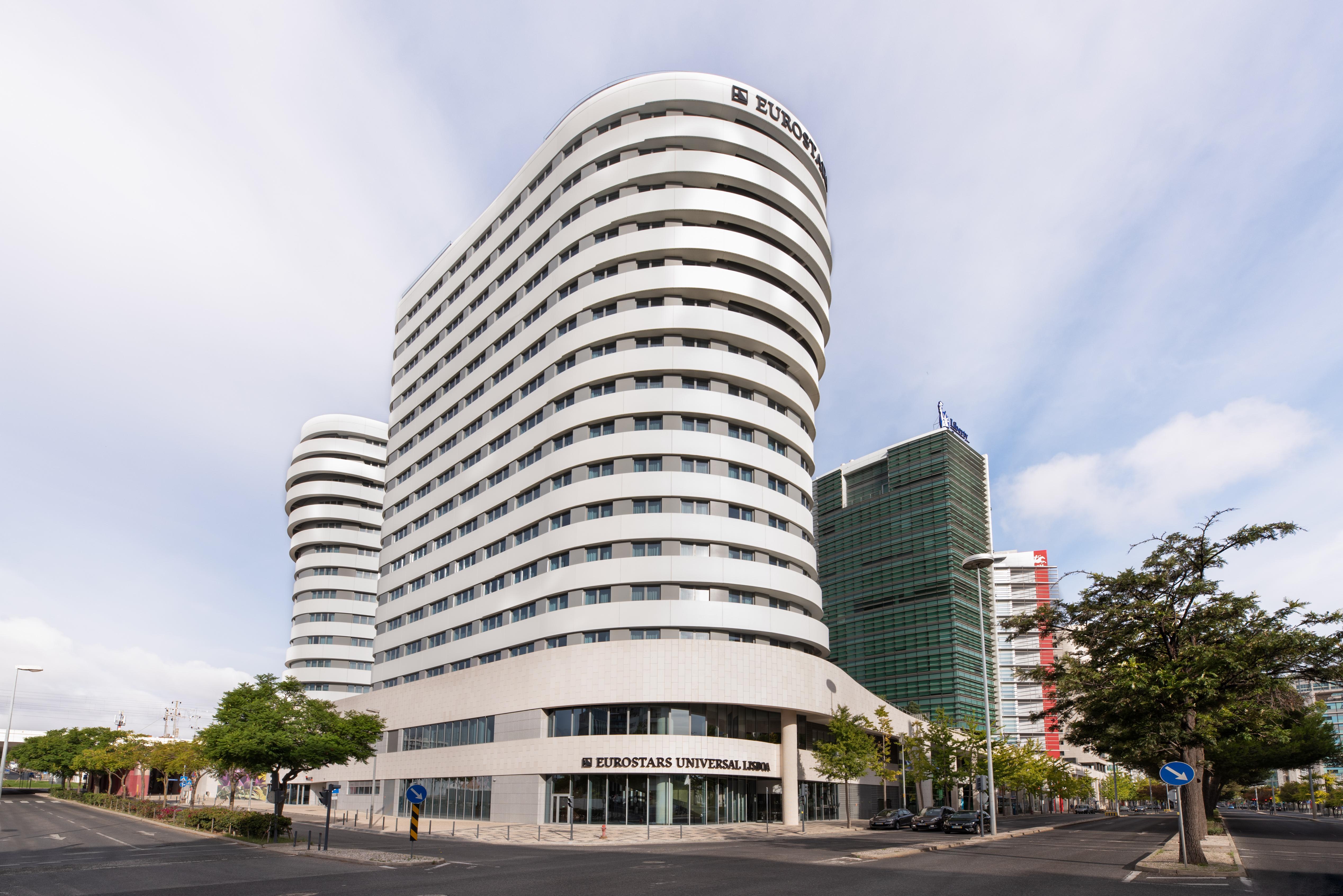 Отель Eurostars Universal Lisboa Экстерьер фото The image shows a modern building with a distinctive architectural design. The structure features a series of curved and wavy lines, giving it a sleek and contemporary look. The façade is primarily white with large windows, which offer plenty of natu