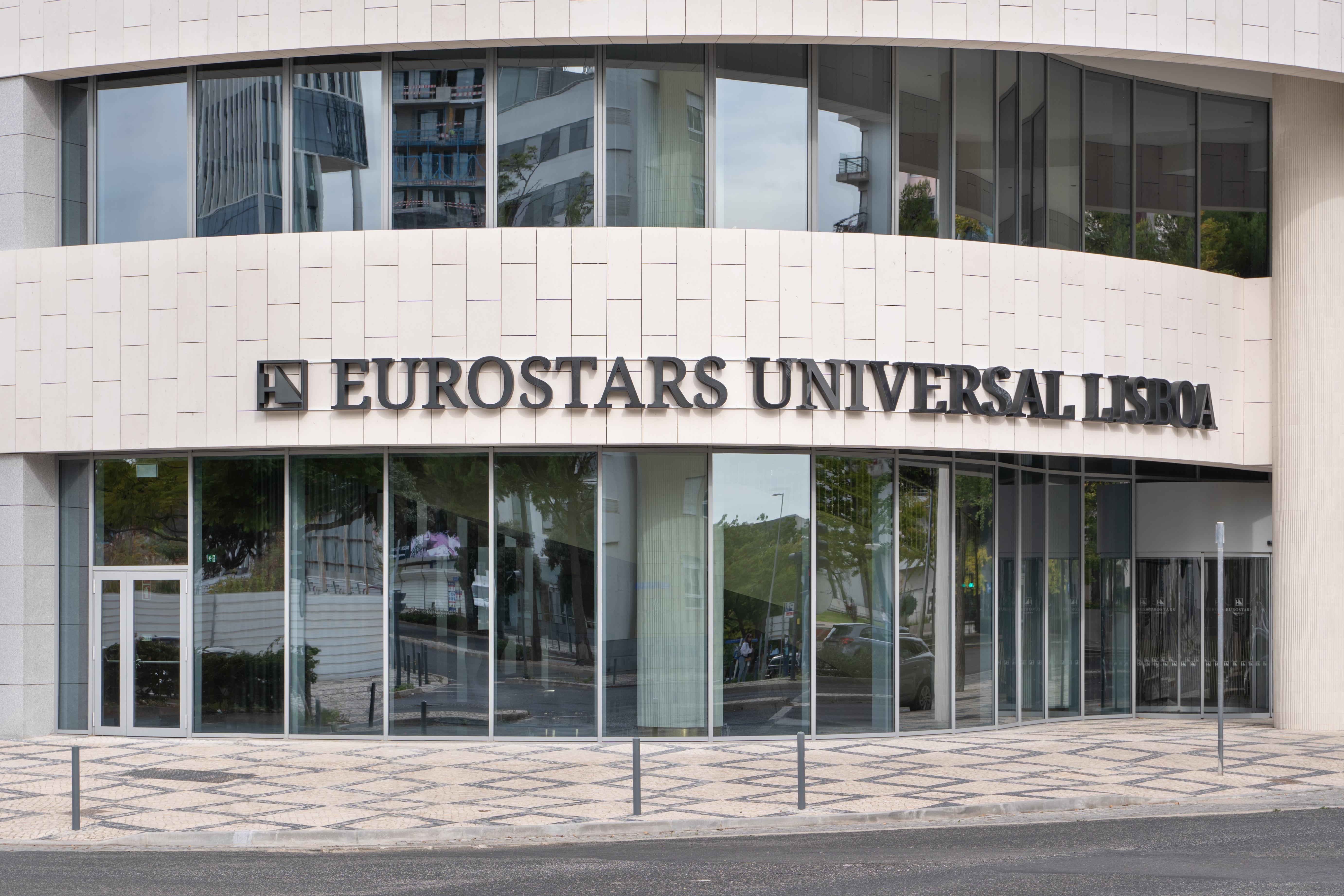 Отель Eurostars Universal Lisboa Экстерьер фото The photo shows the exterior of a building with prominent glass windows. The name "EUROSTARS UNIVERSAL LISBOA" is displayed in large, bold letters on the wall. The architectural design appears modern, characterized by clean lines and a sleek façade. 